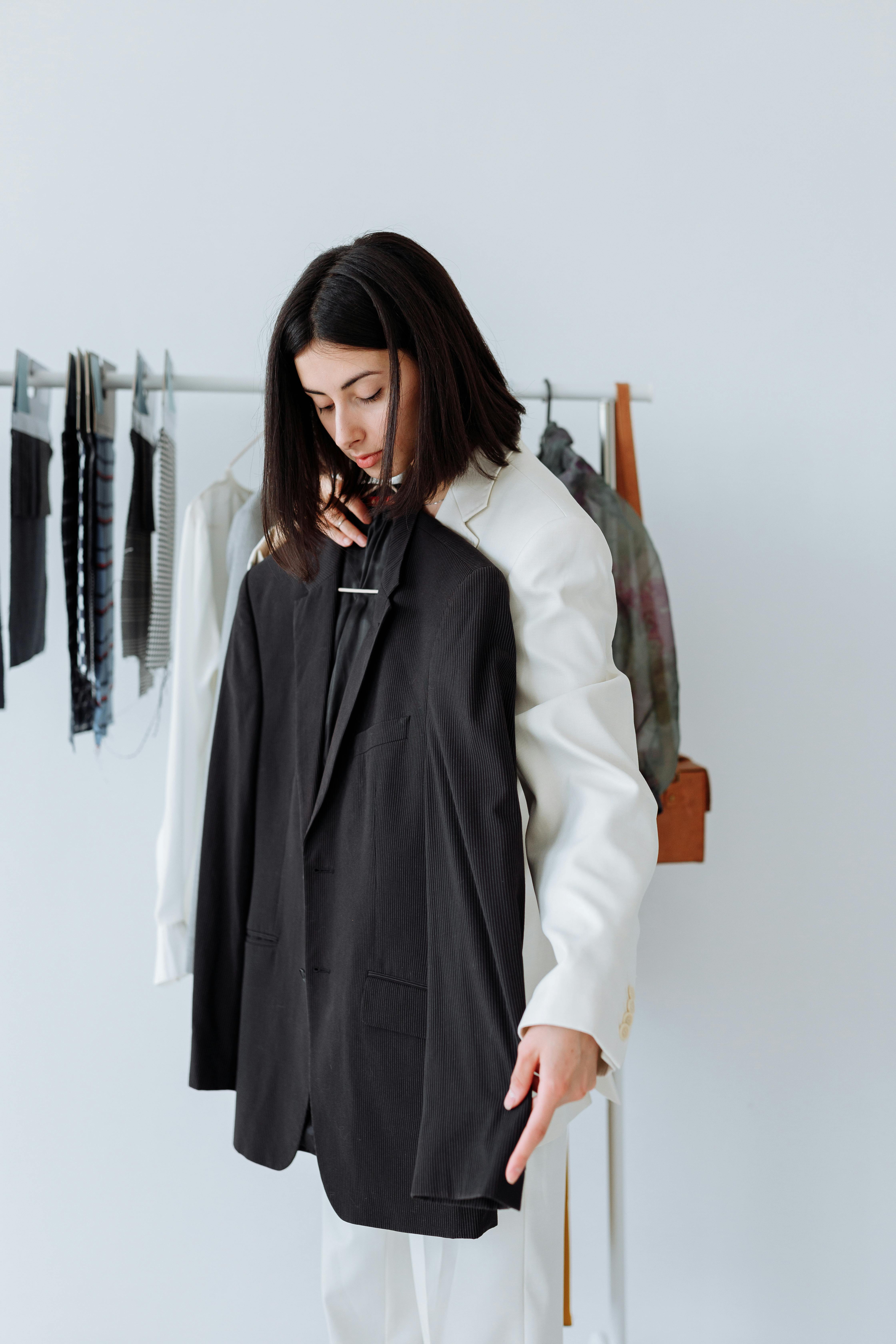 lady holding up a stylish black blazer