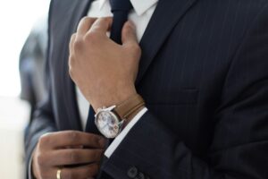 confident man in a suit adjusting his tie